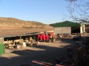 almacén de materiales de construcción con flota de camiones y maquinaria